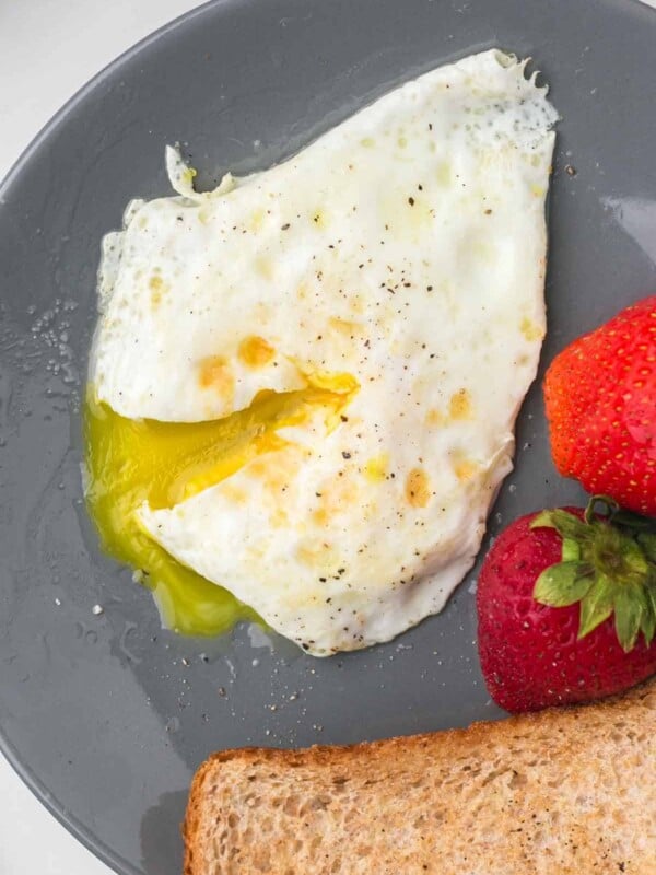 wheat toast with an over easy egg served on a grey plate