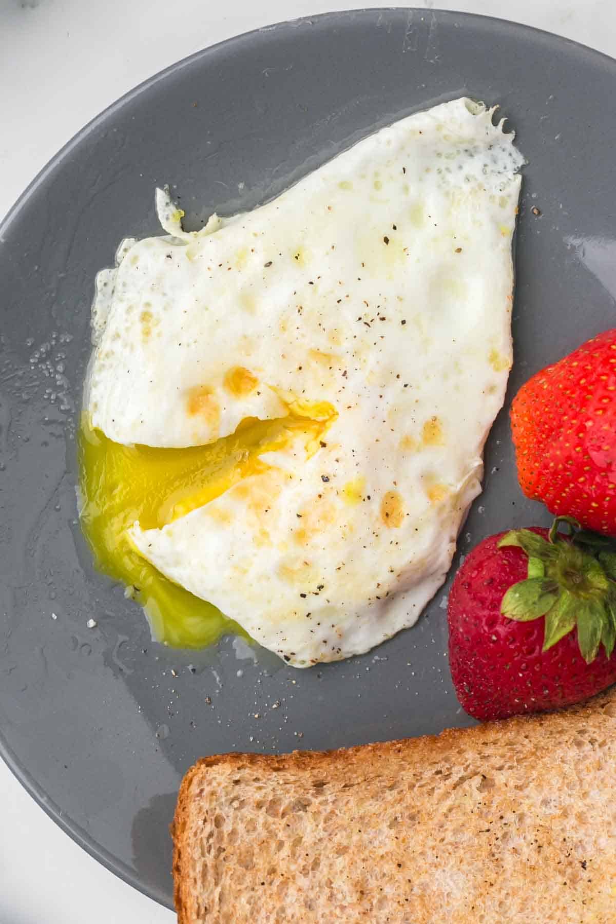 wheat toast with an over easy egg served on a grey plate