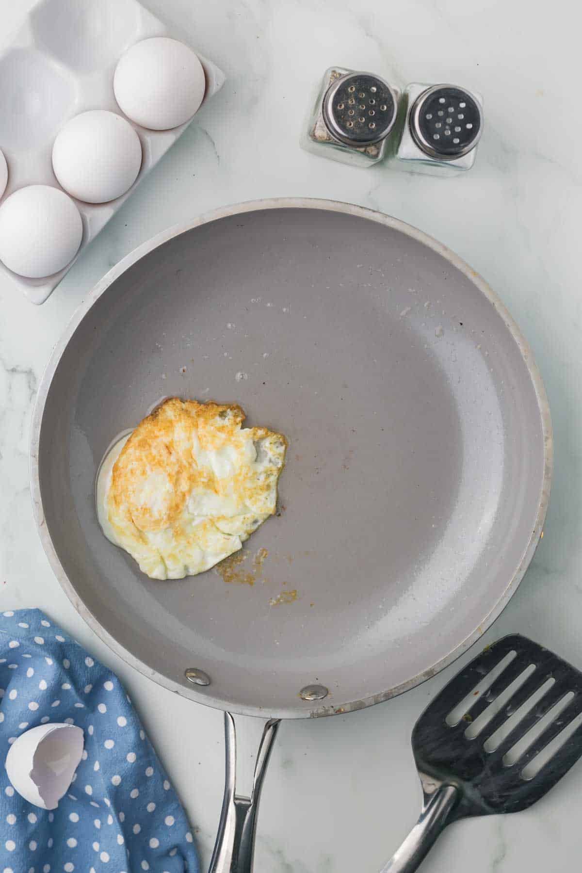 sauté pan with an egg cooking in it