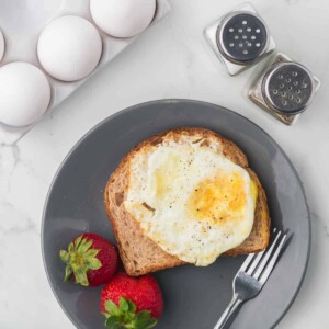 wheat toast with an over hard egg on top served on a grey plate