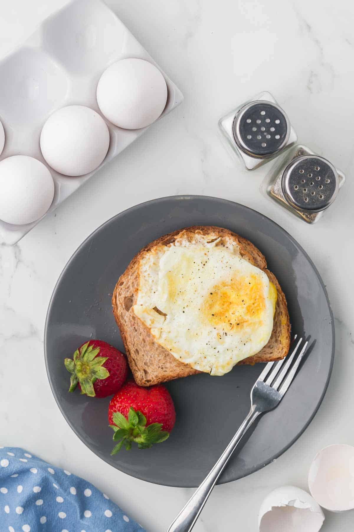 wheat toast with an over hard egg on top served on a grey plate