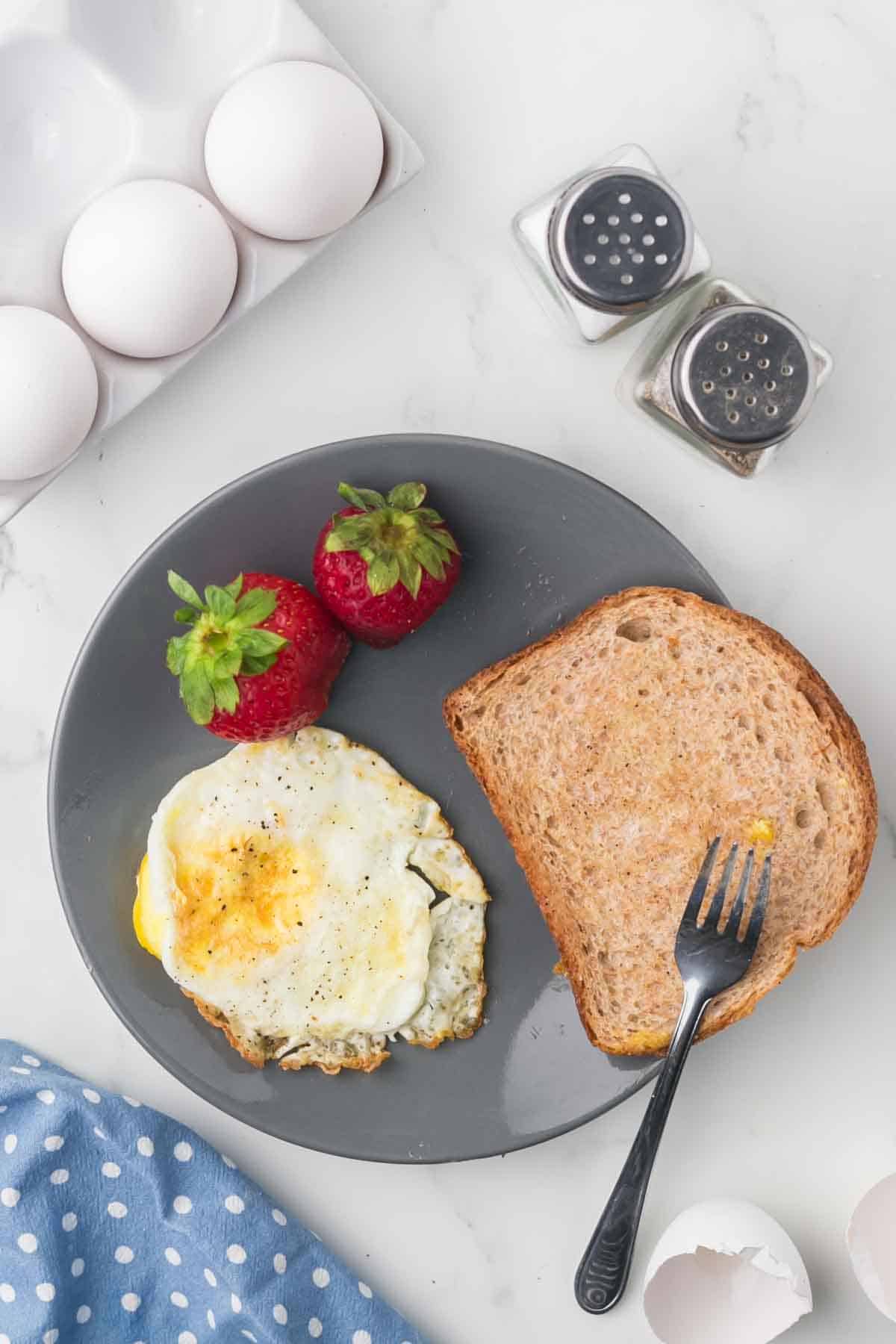 wheat toast with an over hard egg served on a grey plate