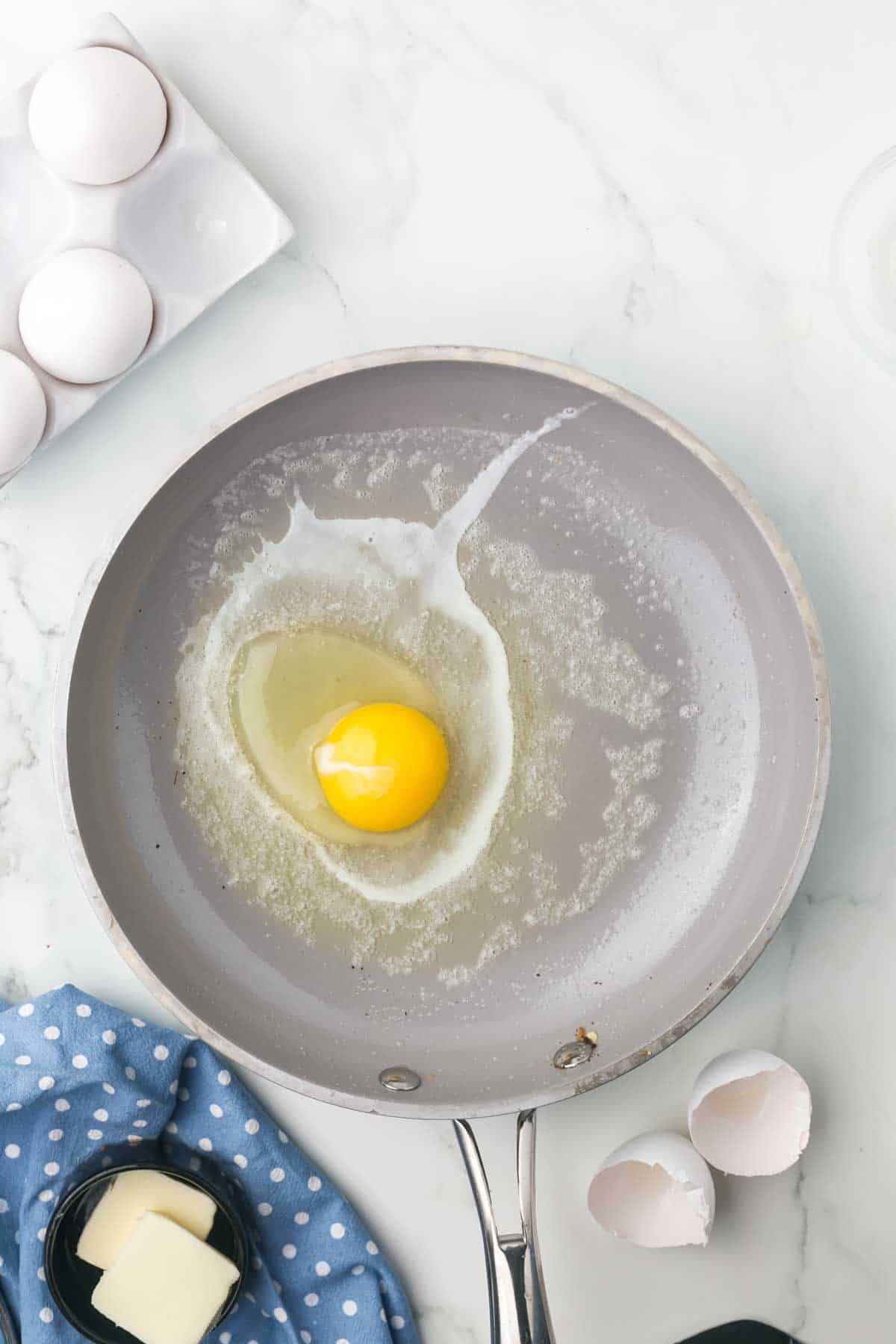 sauté pan with an egg cooking in it
