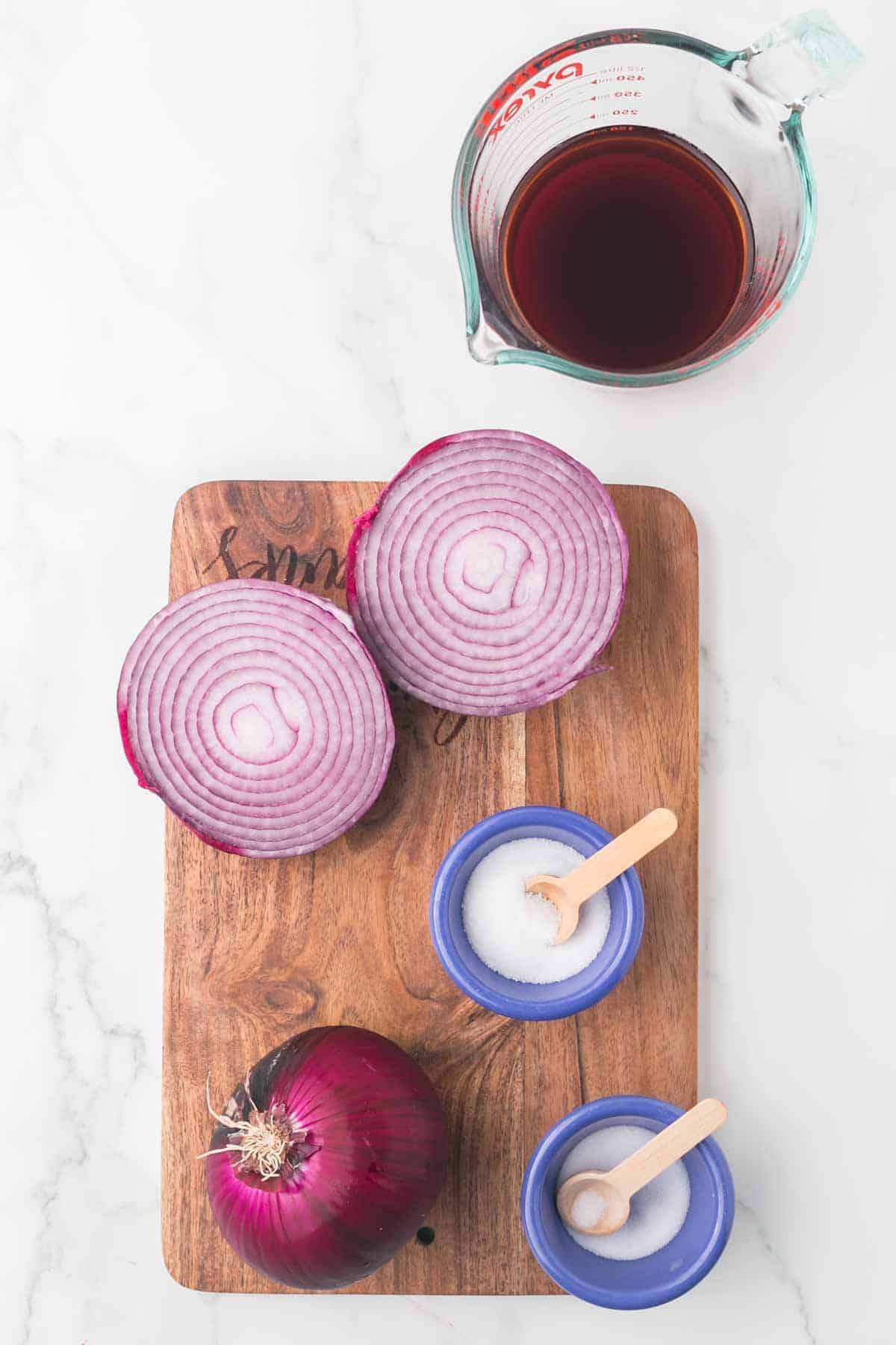 raw ingredients for pickled red onions on a wooden board