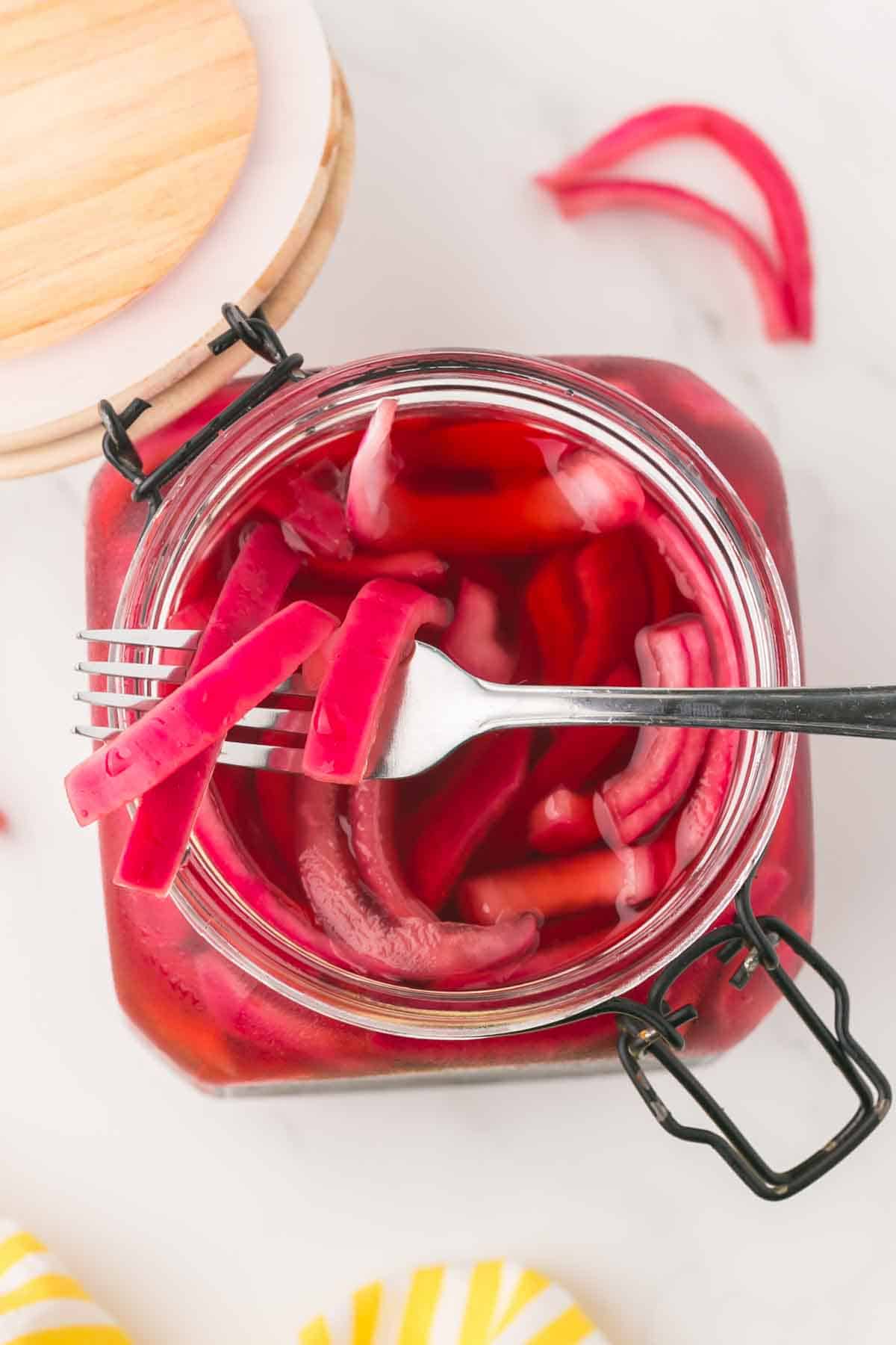 pickled red onions in a jar with a lid