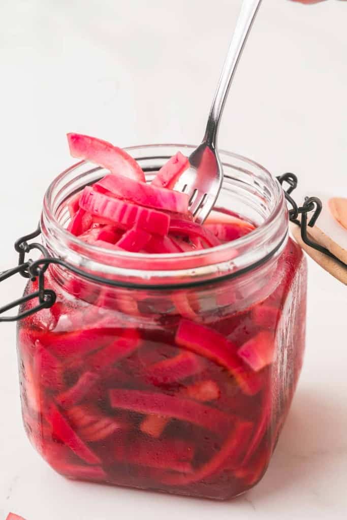 small dish with a lid filled with pickled red onions