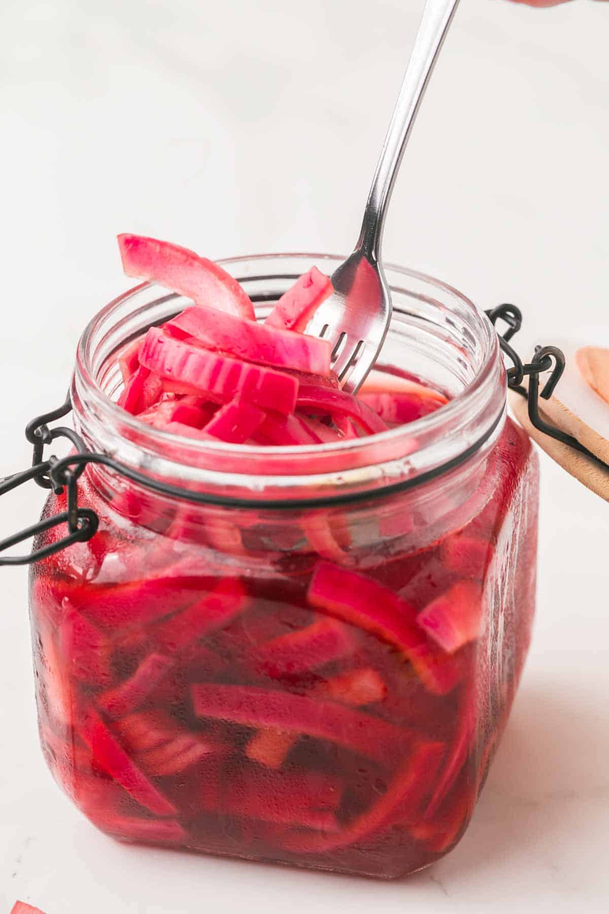 small dish with a lid filled with pickled red onions