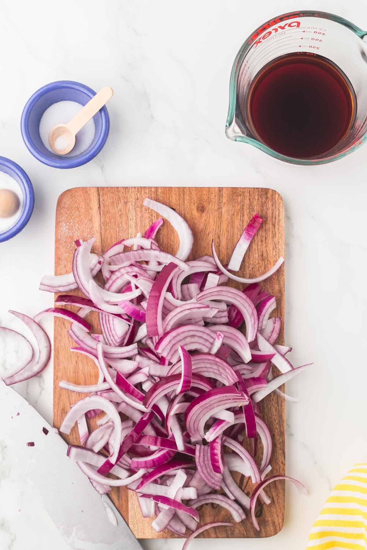 raw ingredients for pickled red onions on a wooden board