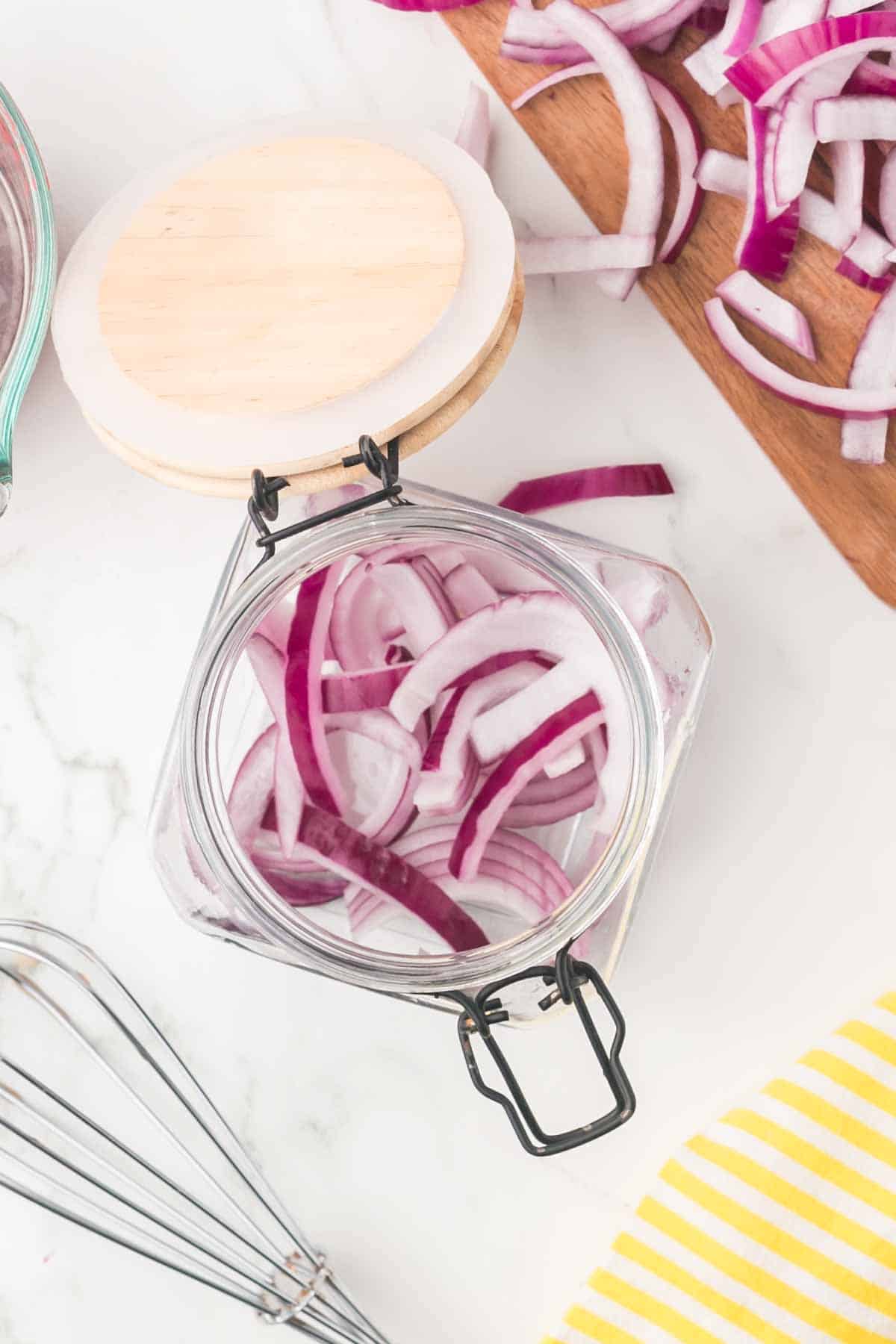 raw ingredients for pickled red onions on a wooden board