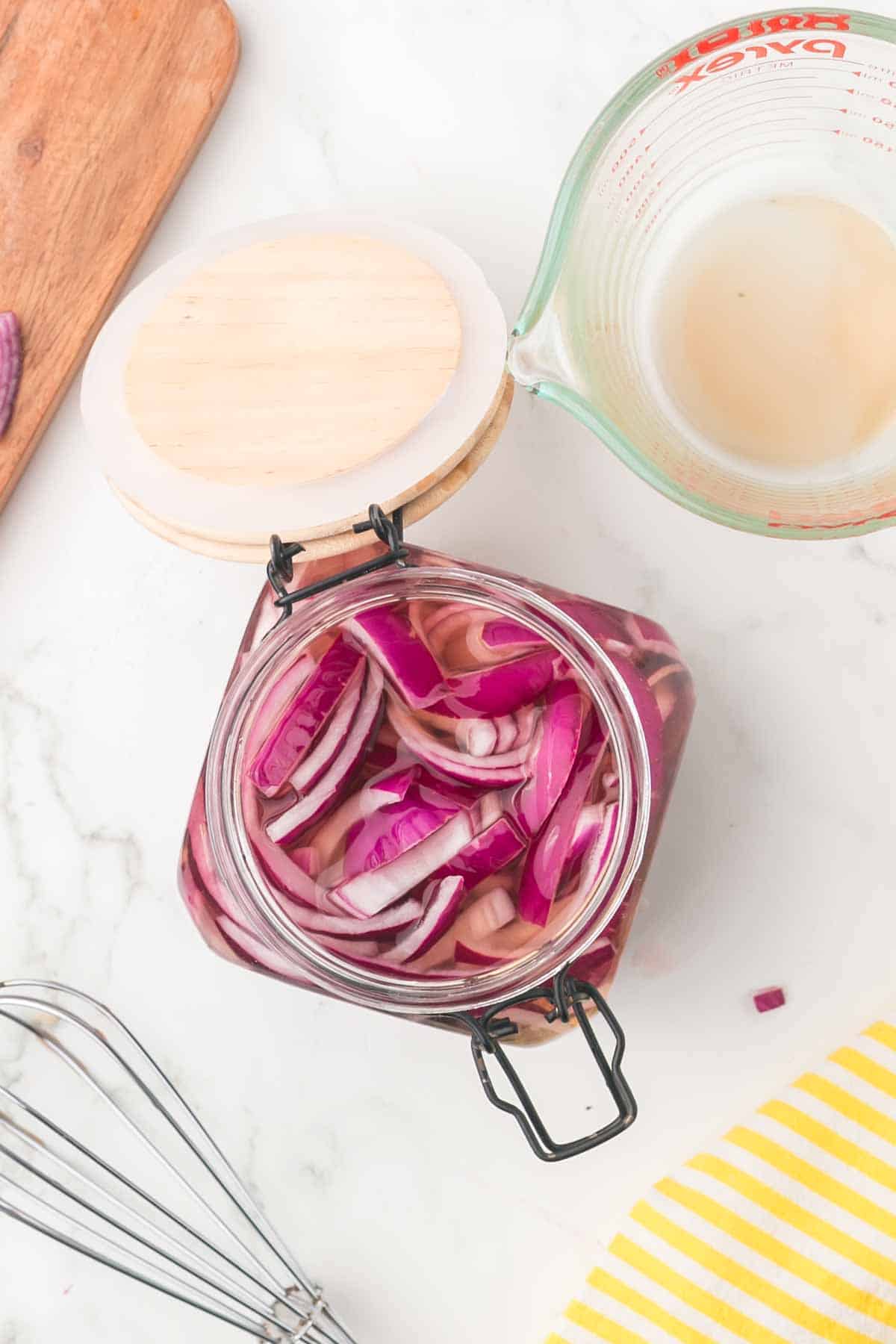 pickled red onions in a jar with a lid