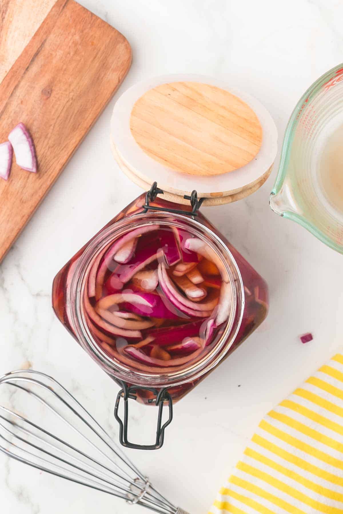 pickled red onions in a jar with a lid