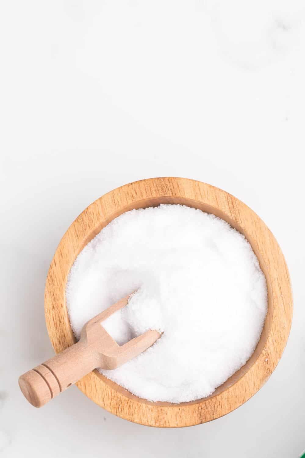 top view wooden bowl and spoon filled with pickling salt