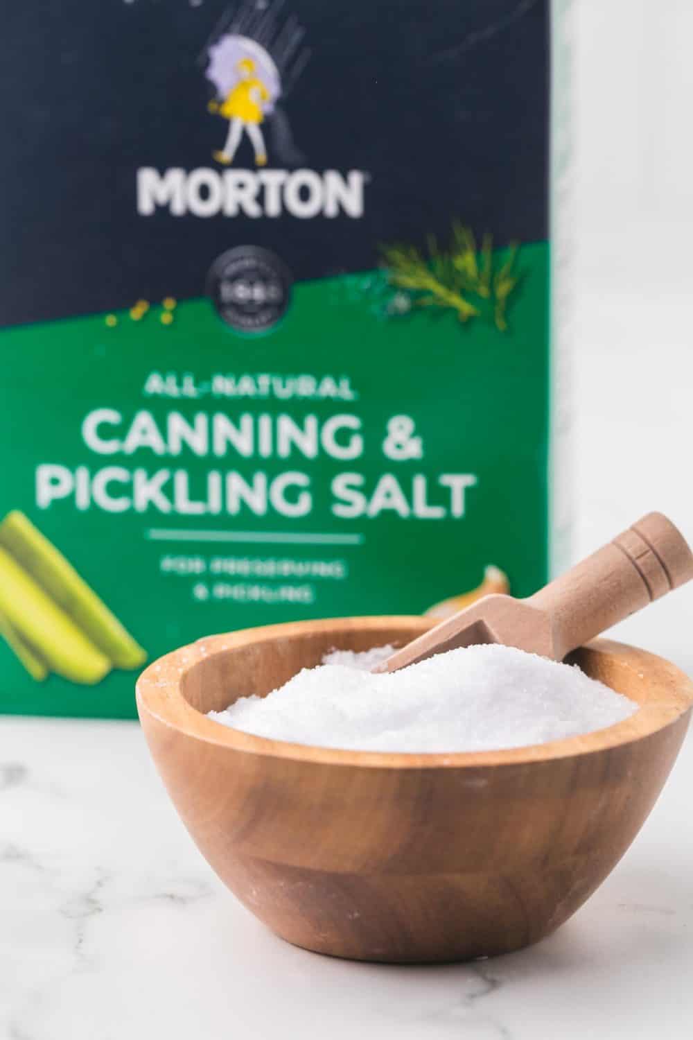 paper box of Morton's all natural canning and pickling salt with a wooden bowl of salt