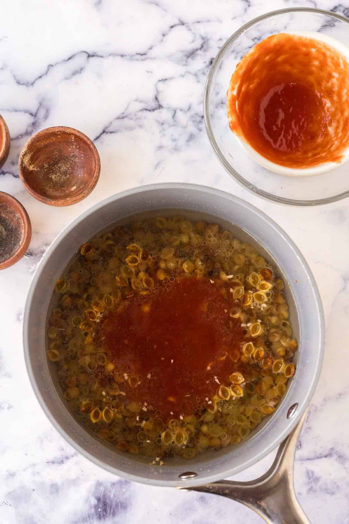 sauce pan with raw pasta for sopitas ingredients