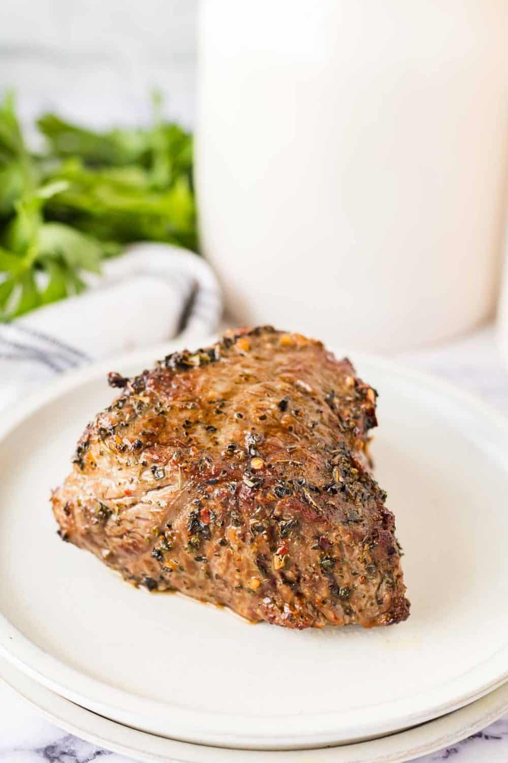 top view of a white plate with a marinated steak