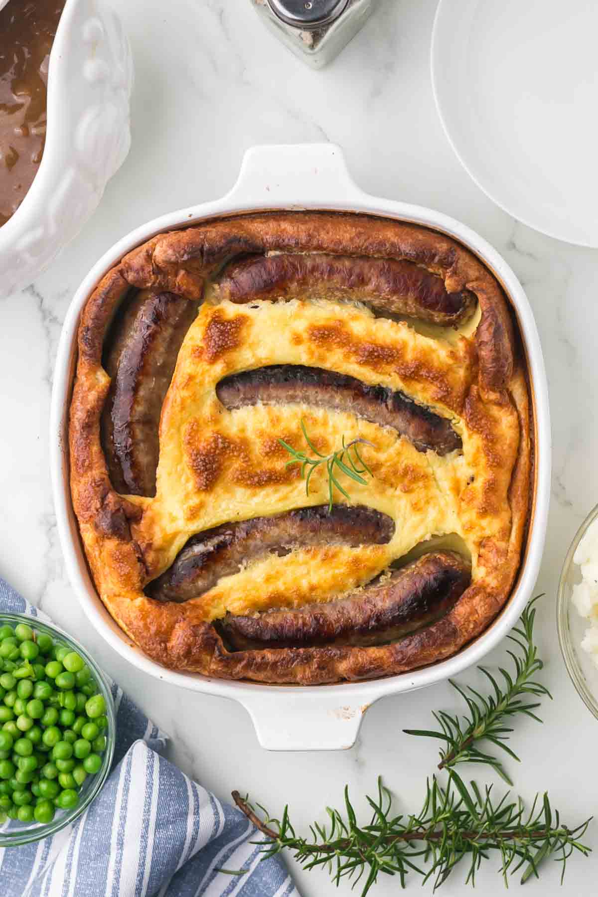 top view of a toad in a hole in a casserole dish baked and crispy dough