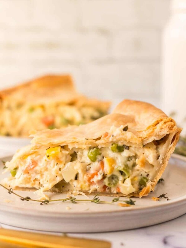 side view of one triangle slice of baked turkey pot pie on a plate
