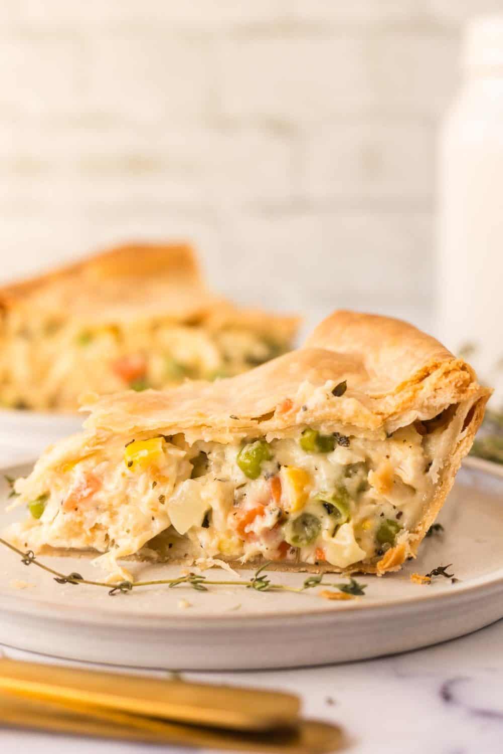 side view of one triangle slice of baked turkey pot pie on a plate