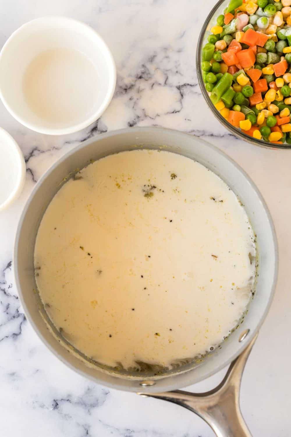 Adding chicken broth and heavy cream to the pot.