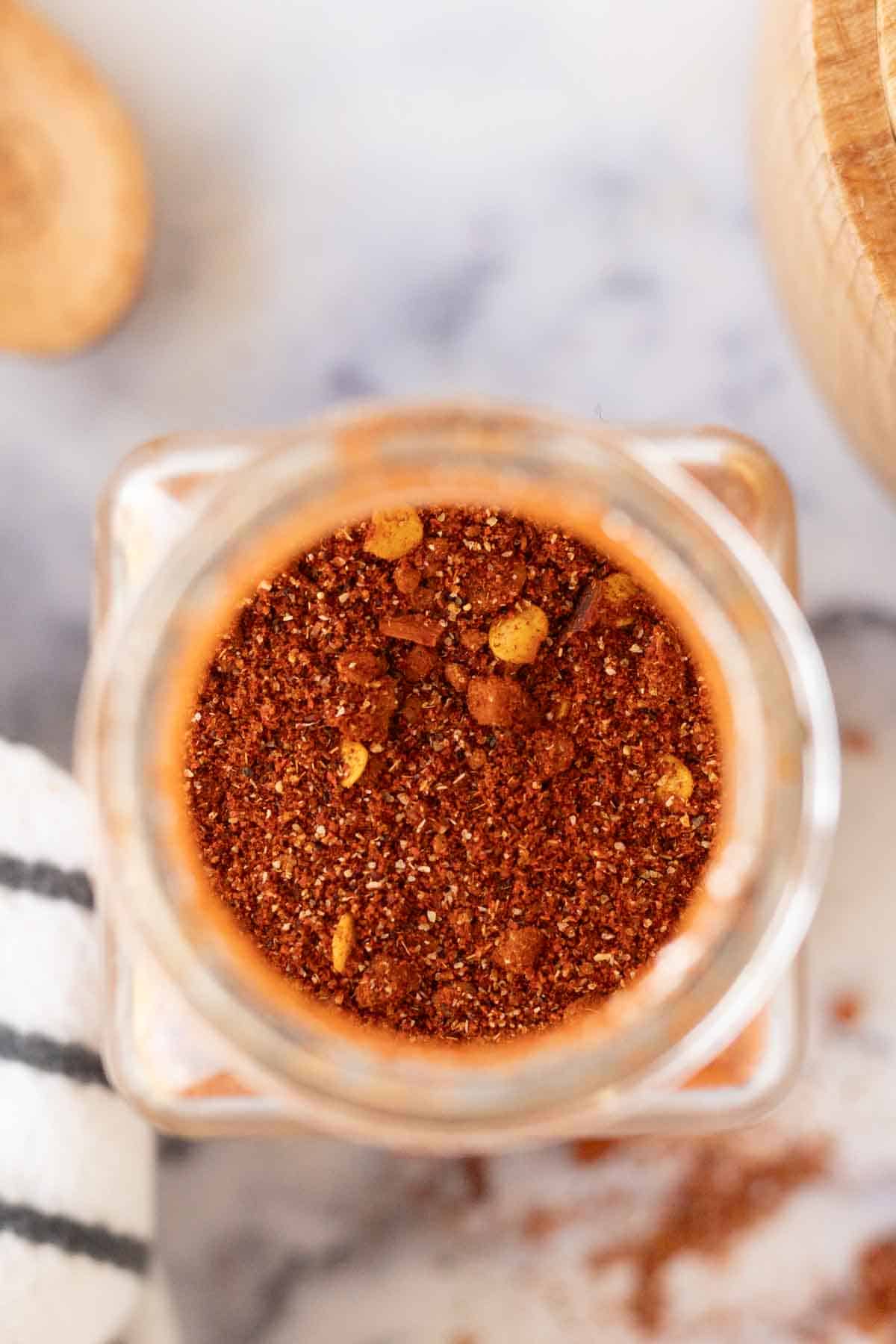 a photo top view directly inside a glass seasoning container filled homemade adobo seasoning