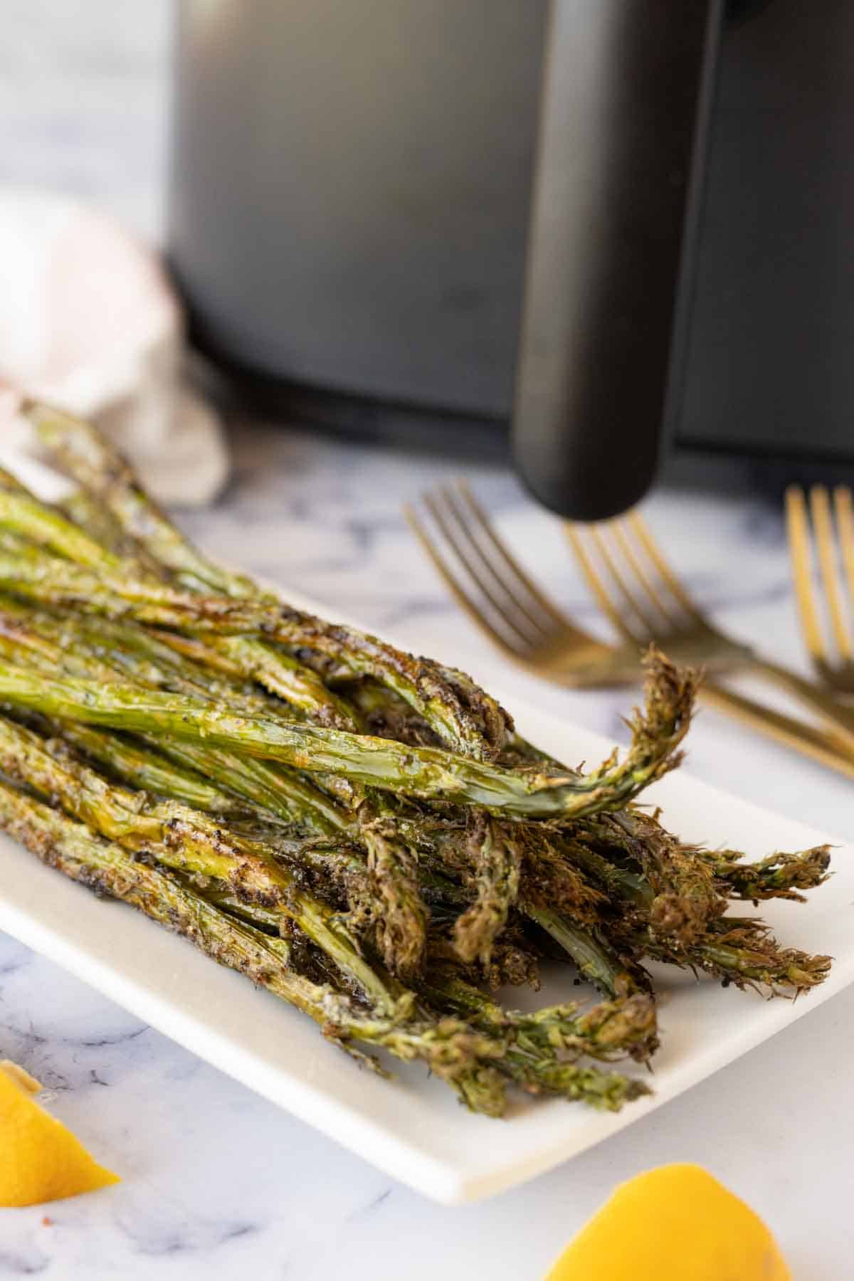 tips of air fryer asparagus on a long rectangle plate