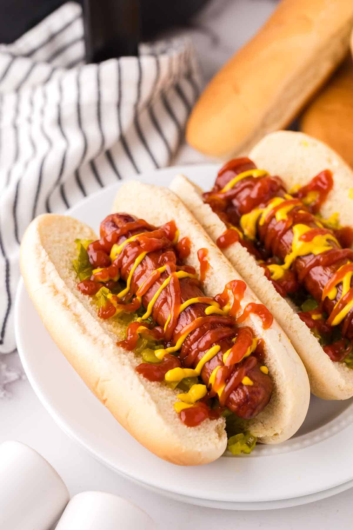 brats with ketchup mustard and relish in a traditional bun