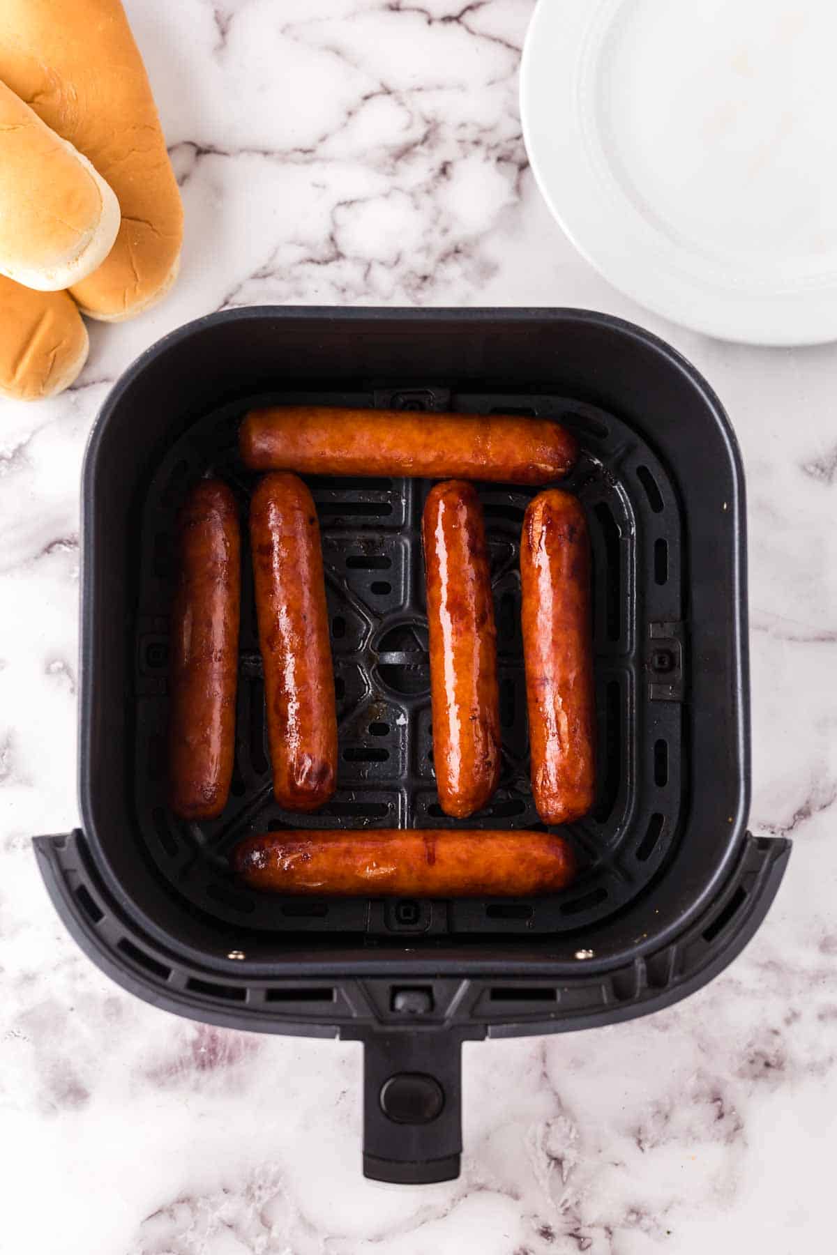 cooked air fryer brats in the black air fryer basket