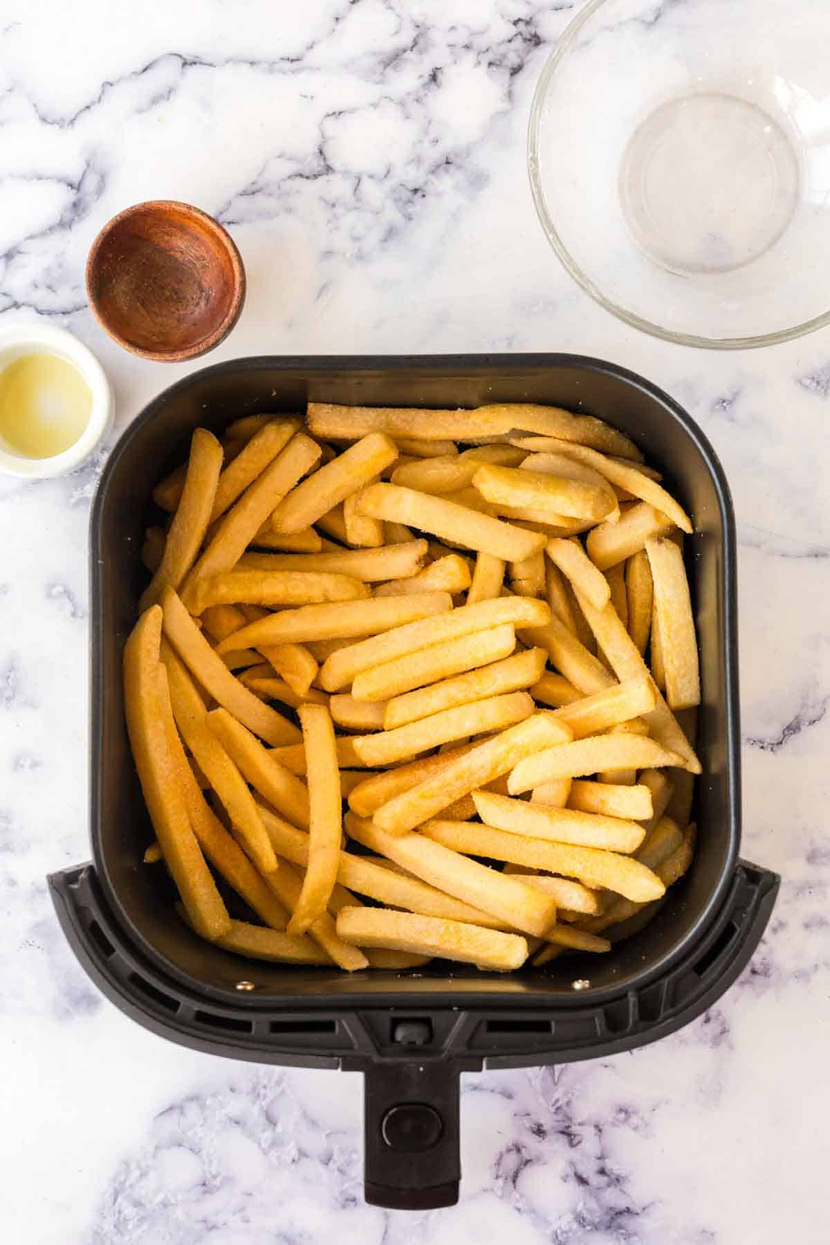 an air fryer basket of french fries.