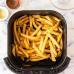 an air fryer basket of french fries.