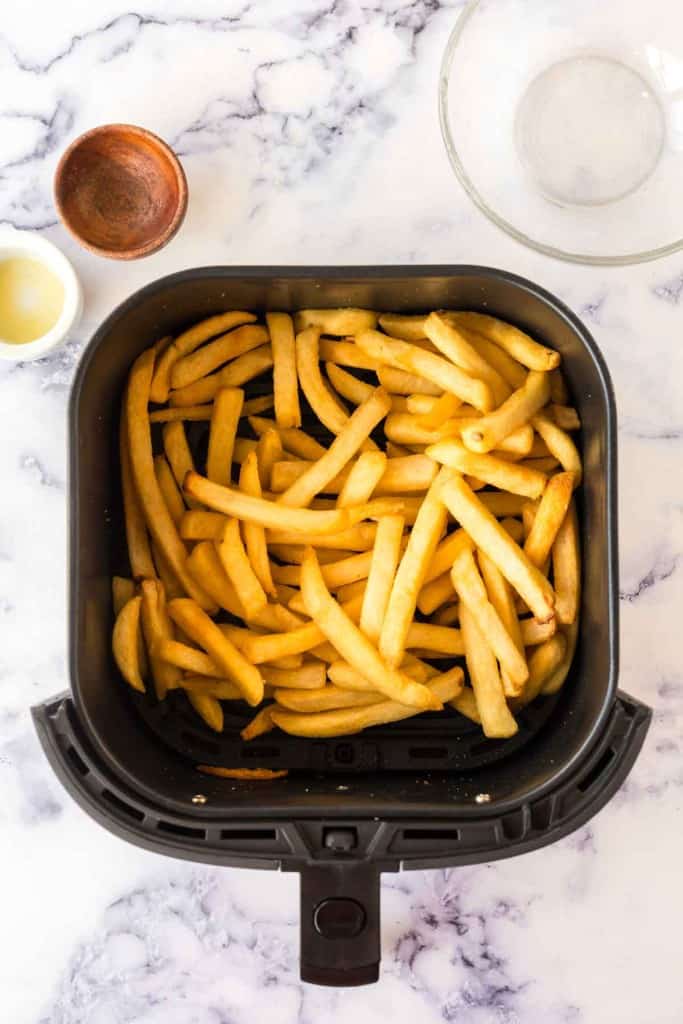 an air fryer basket of french fries.