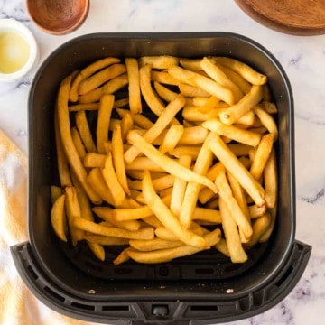 an air fryer basket of french fries.