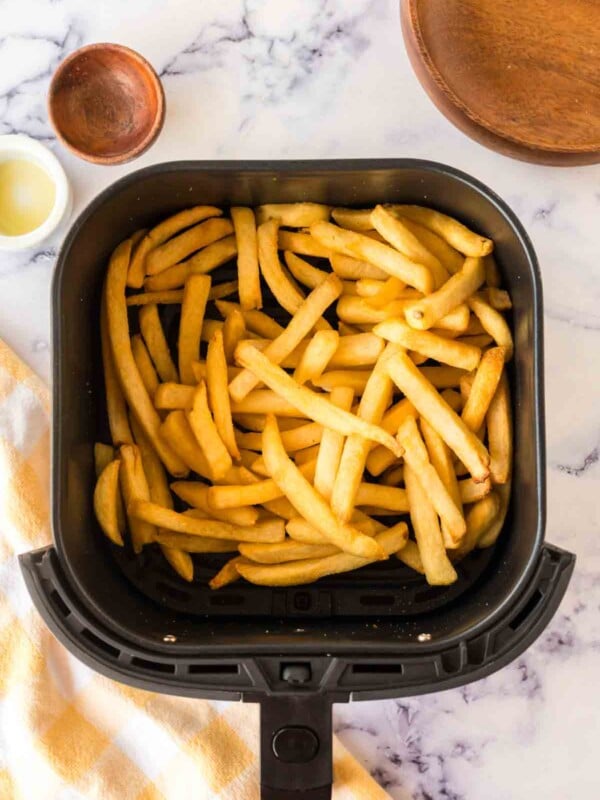 an air fryer basket of french fries.