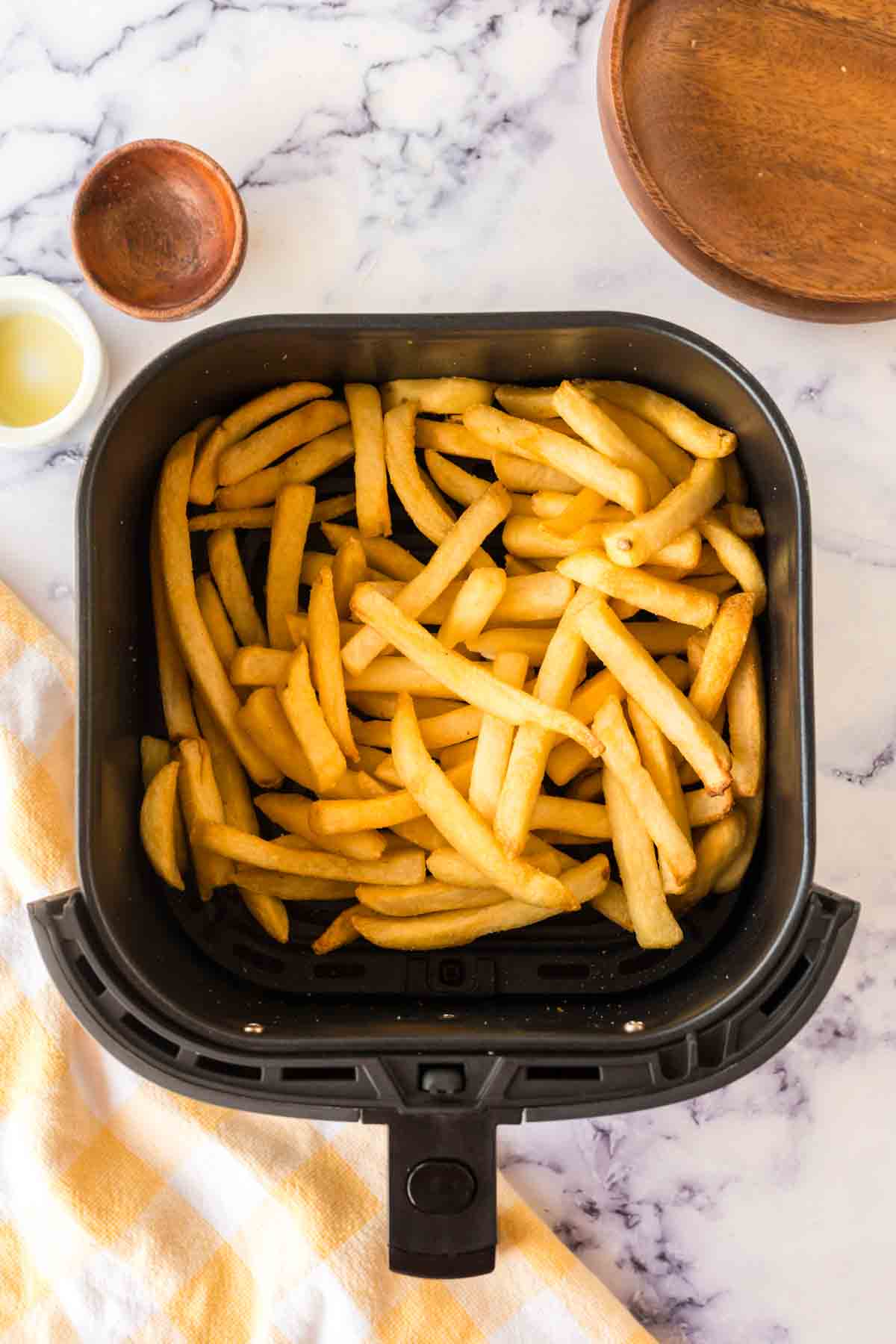 an air fryer basket of french fries.