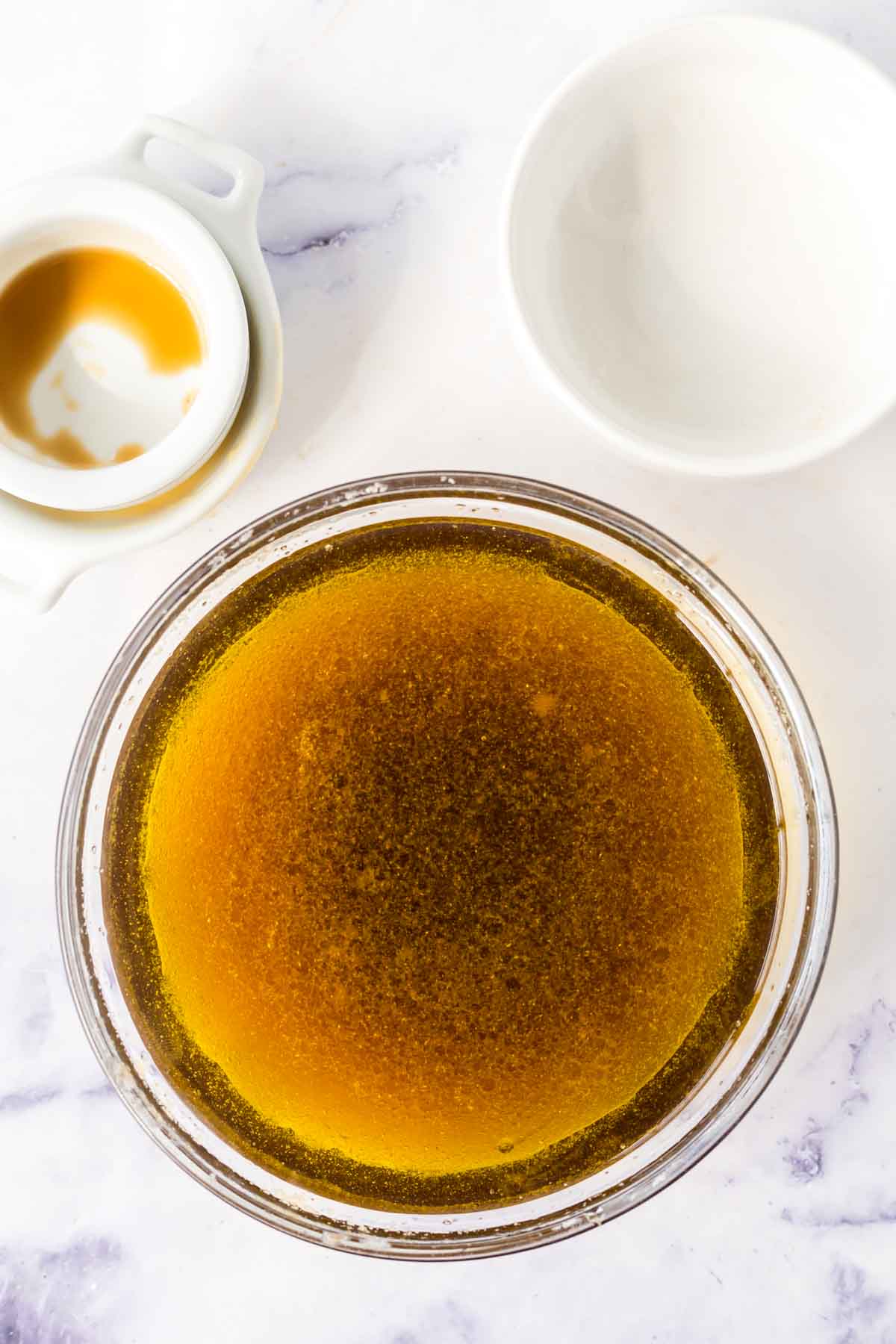 clear mixing bowl with stages of asian salad dressing ingredients