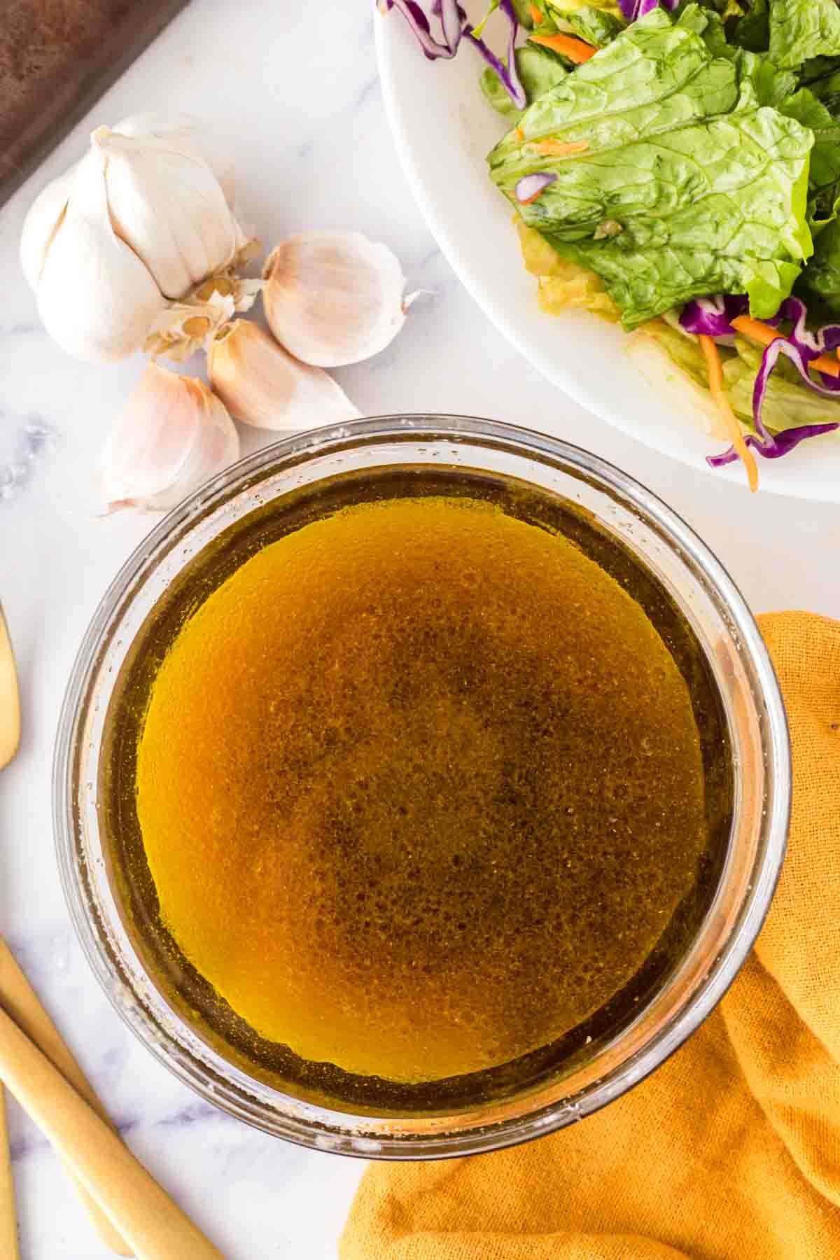 clear mixing bowl with stages of asian salad dressing ingredients