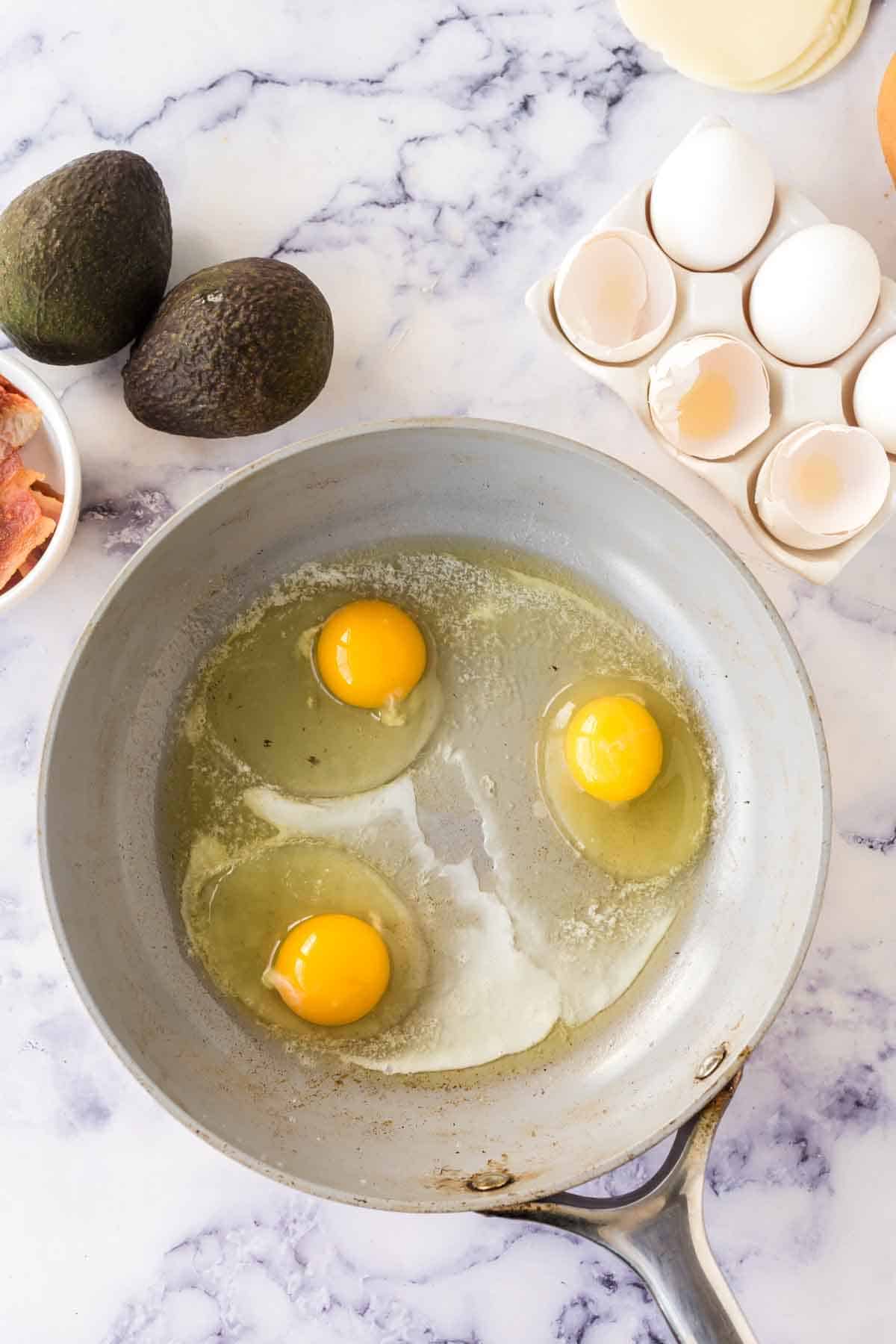 pan with three eggs frying inside