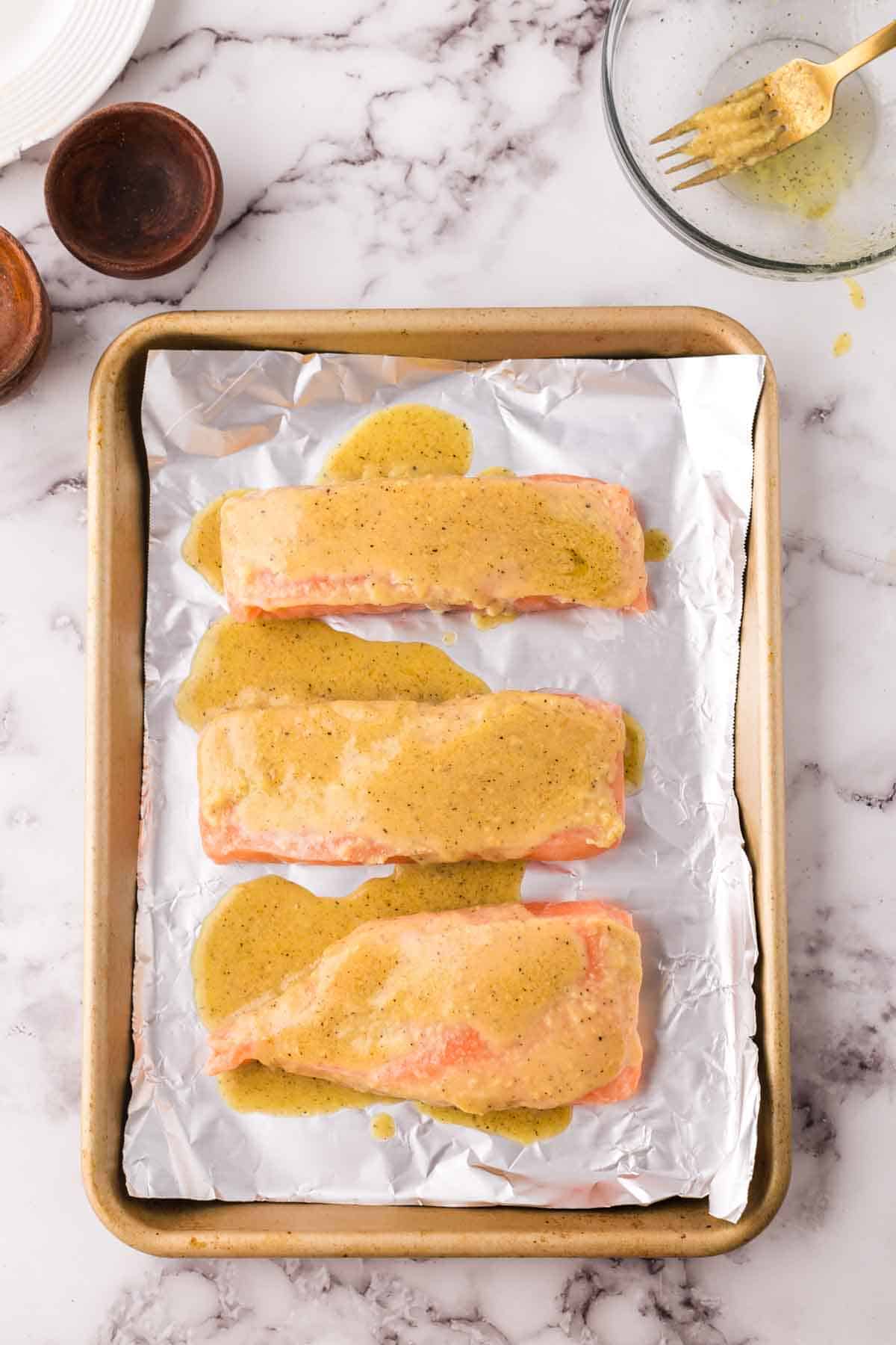 raw salmon filets on a baking tray