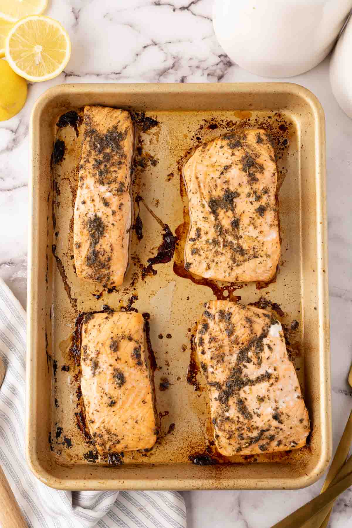 four salmon filets seasoned and baked on a cookie tray