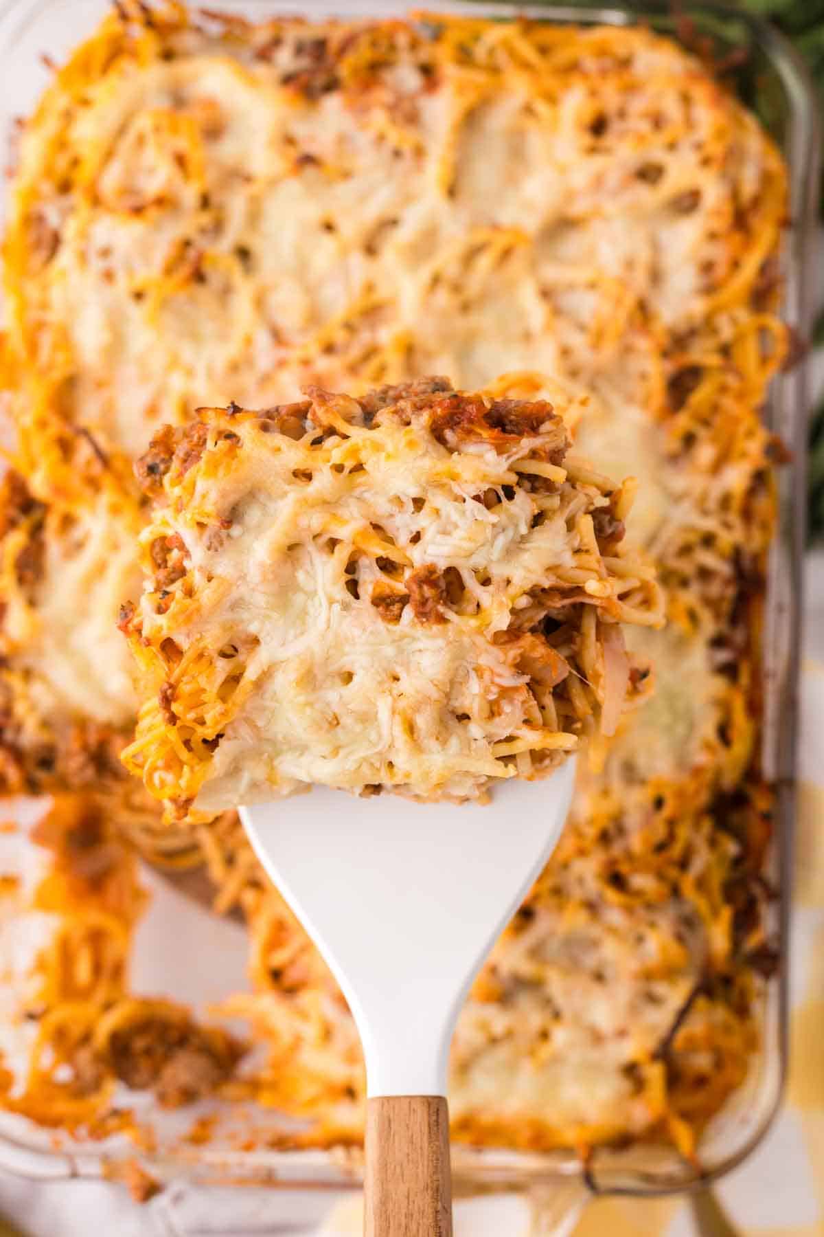Up close view of baked spaghetti on a spatula.