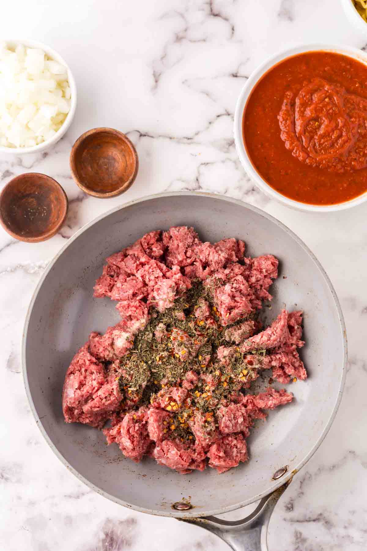 Ground beef with seasonings in a skillet.