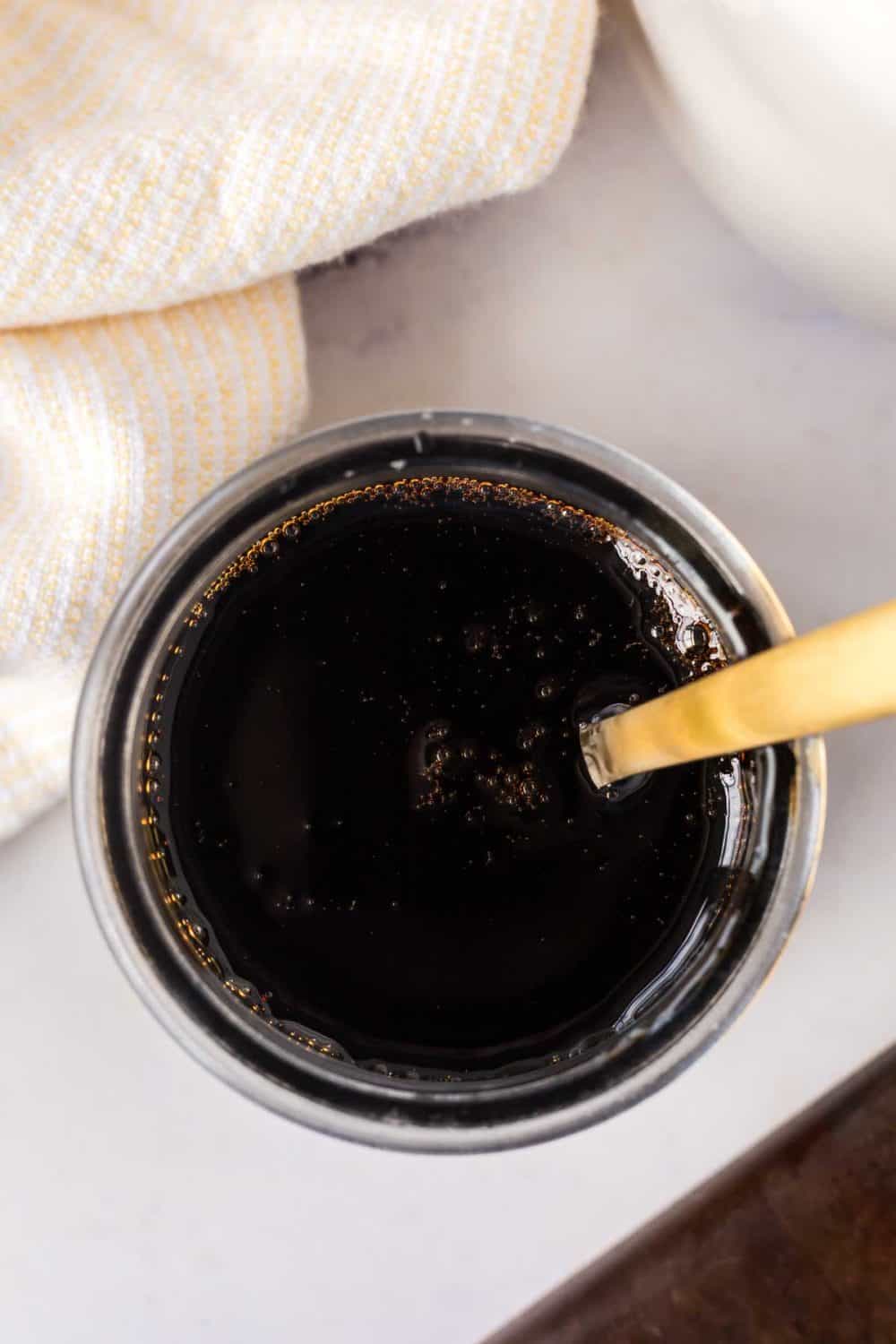 top view of a dish of balsamic glaze with a spoon in it