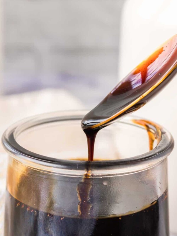 spooning a sticky drip of balsamic glaze from a small glass dish