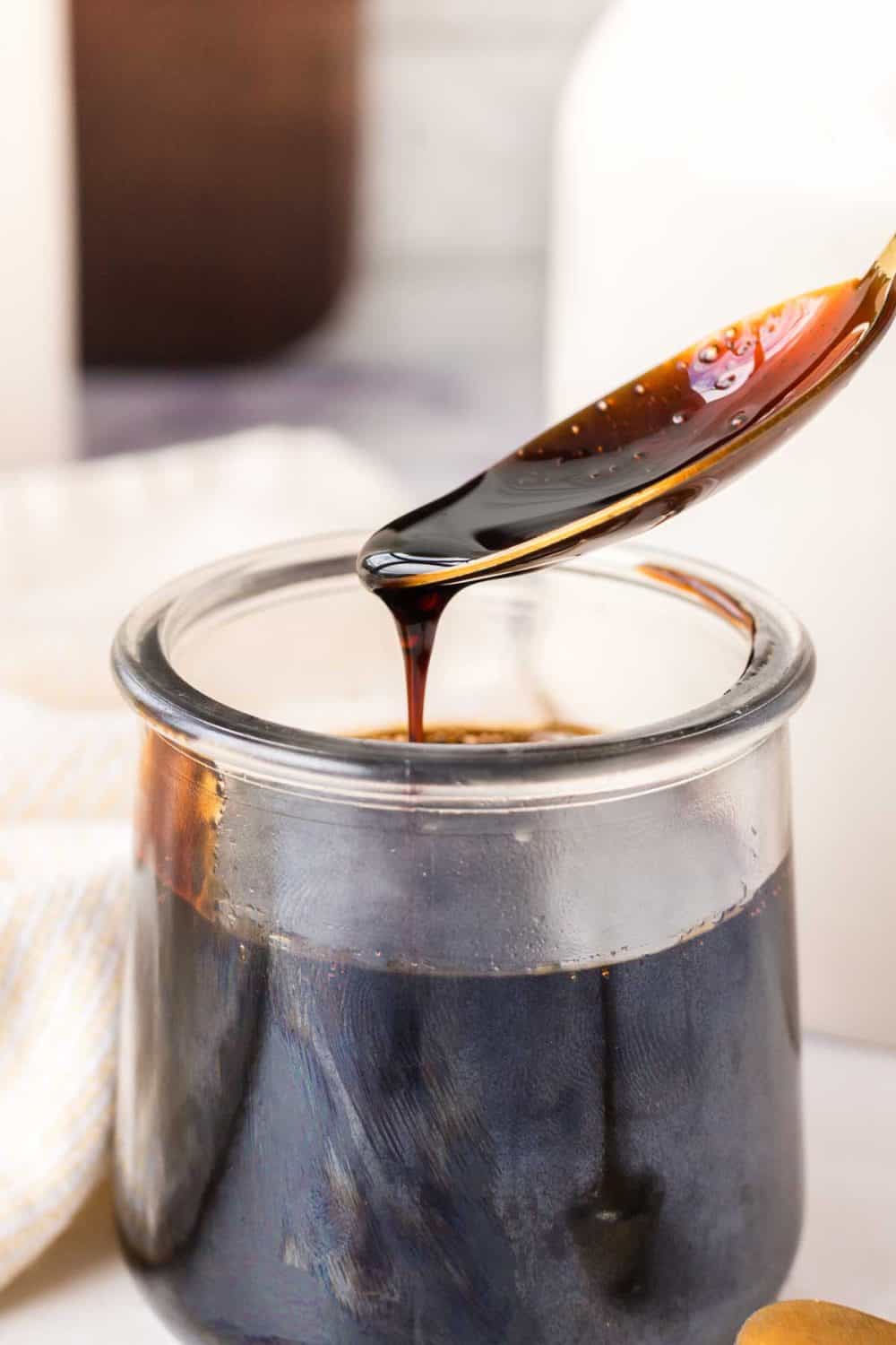 spooning a sticky drip of balsamic glaze from a small glass dish
