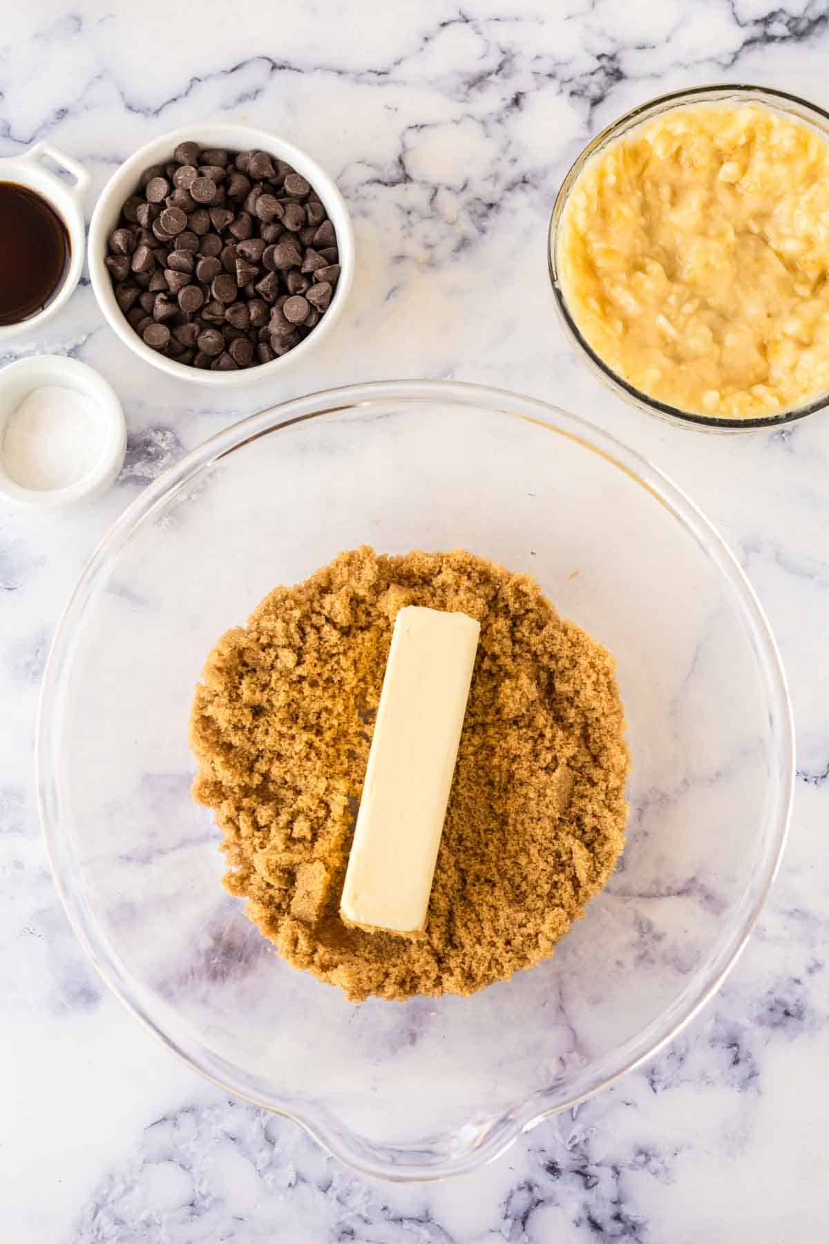 clear mixing bowl with ingredients for the dough for banana chocolate chip muffins