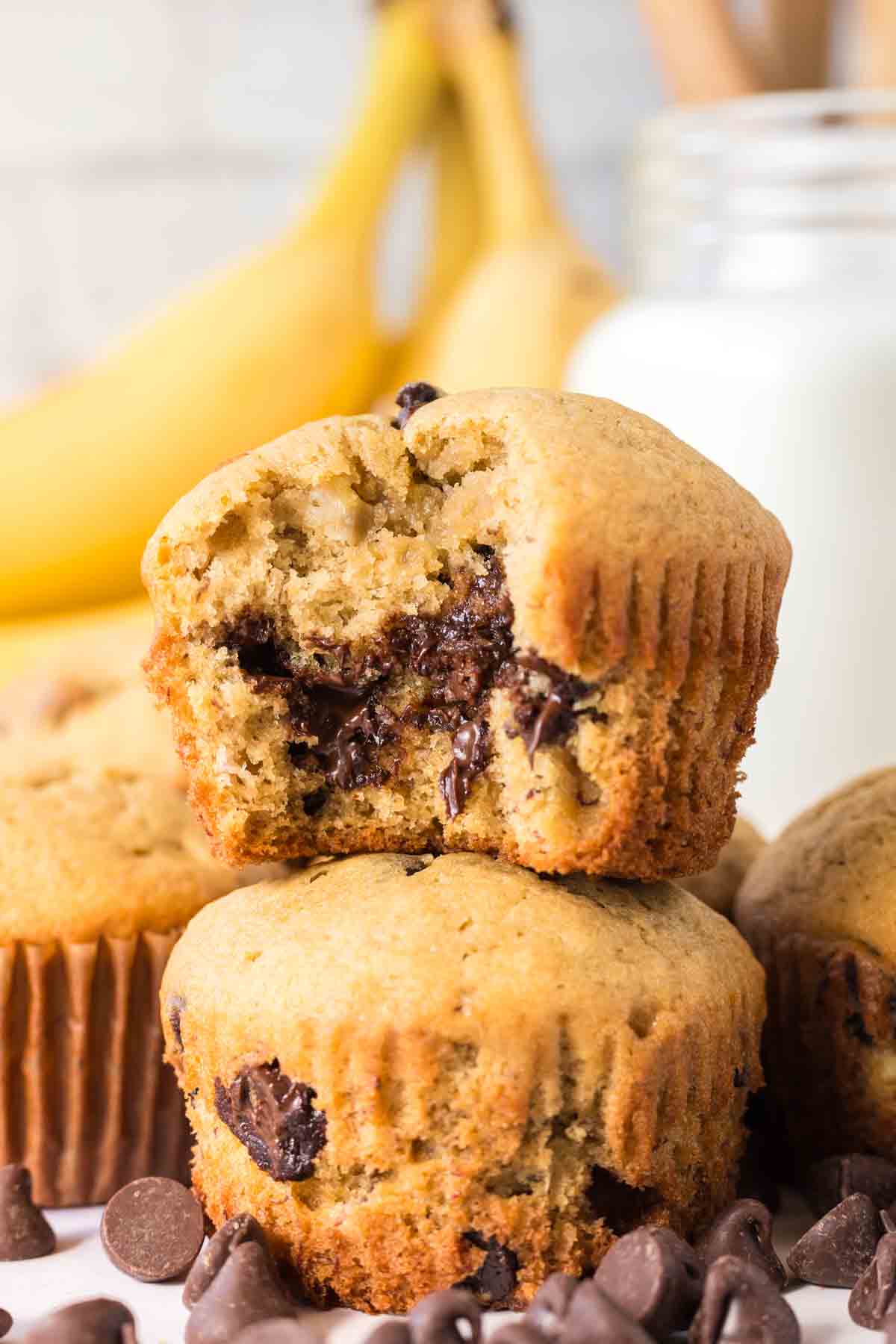 stack of banana chocolate chip muffins with the top one having been bit
