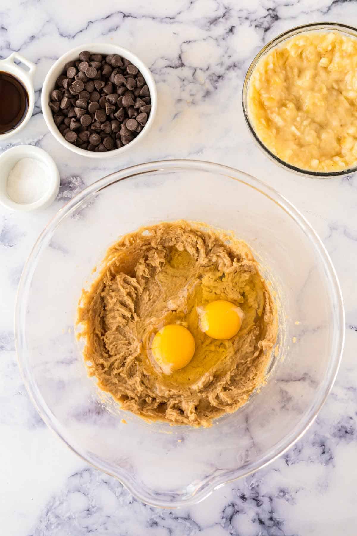 clear mixing bowl with ingredients for the dough for banana chocolate chip muffins