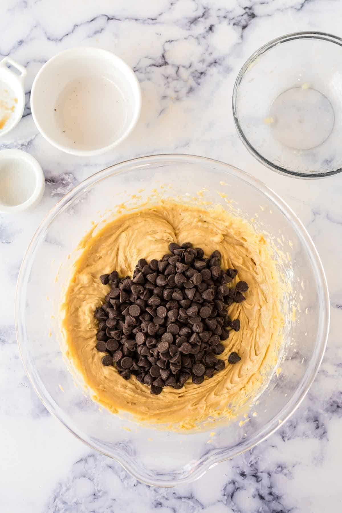 clear mixing bowl with ingredients for the dough for banana chocolate chip muffins