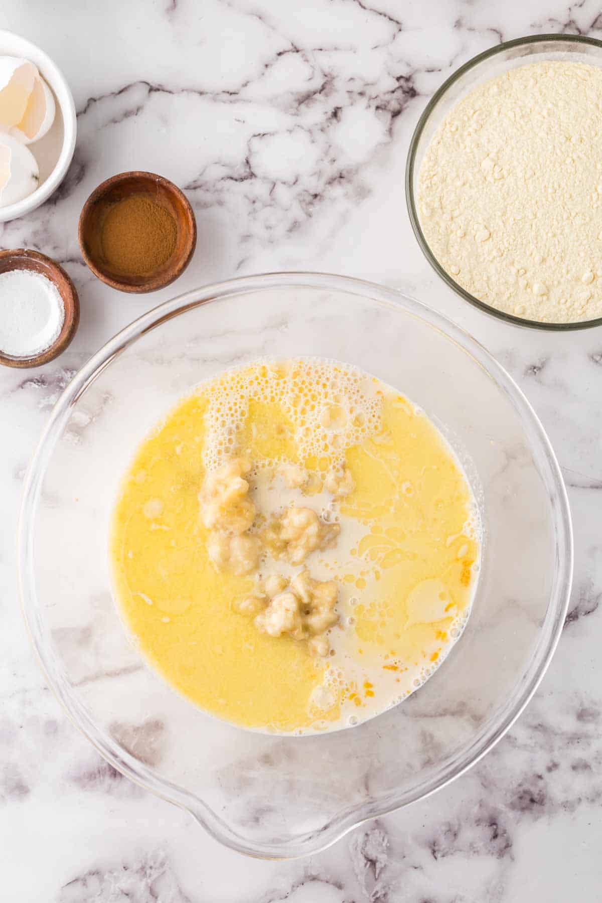 clear mixing bowl with banana pancake ingredients