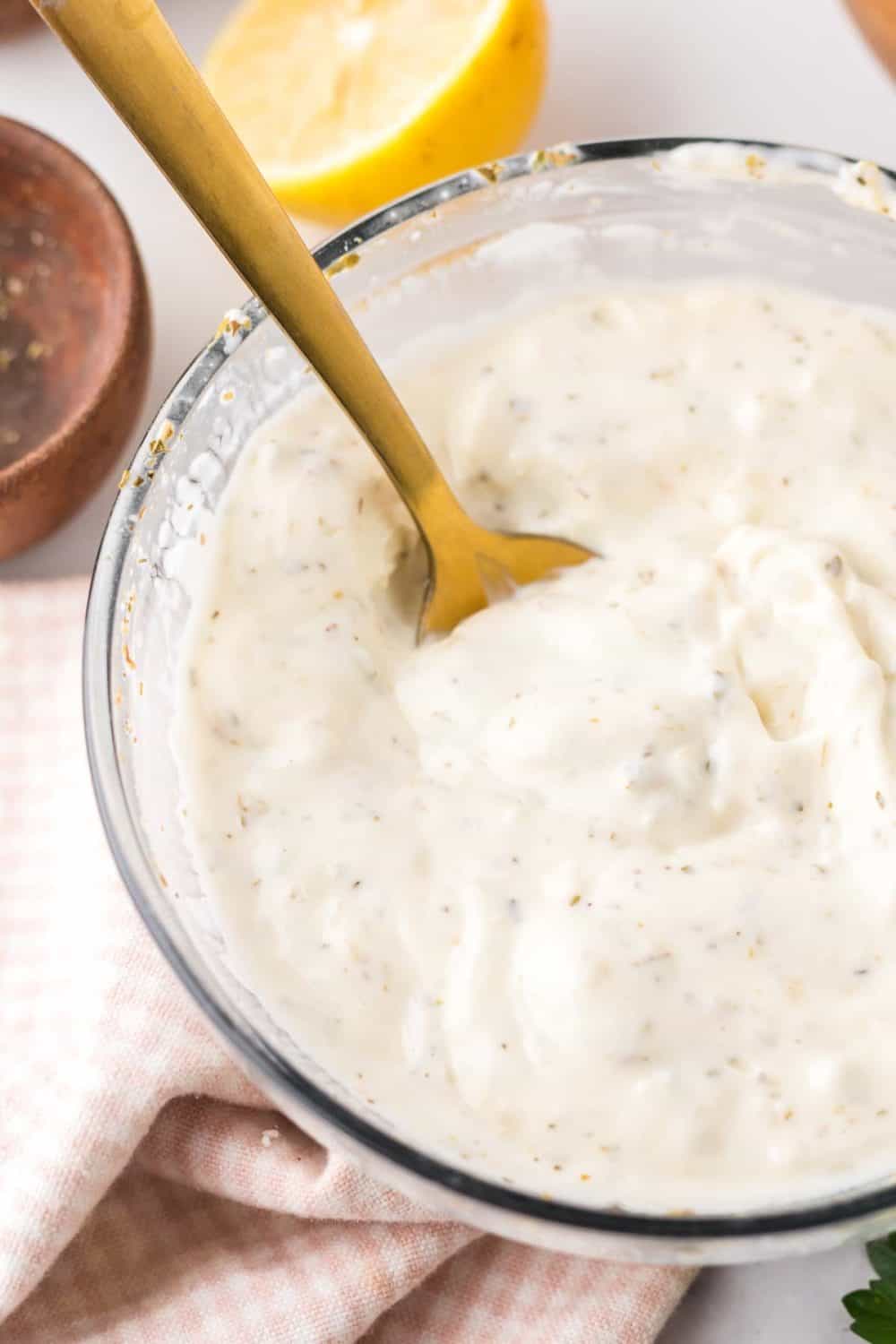 a spoon in a bowl of blue cheese dressing