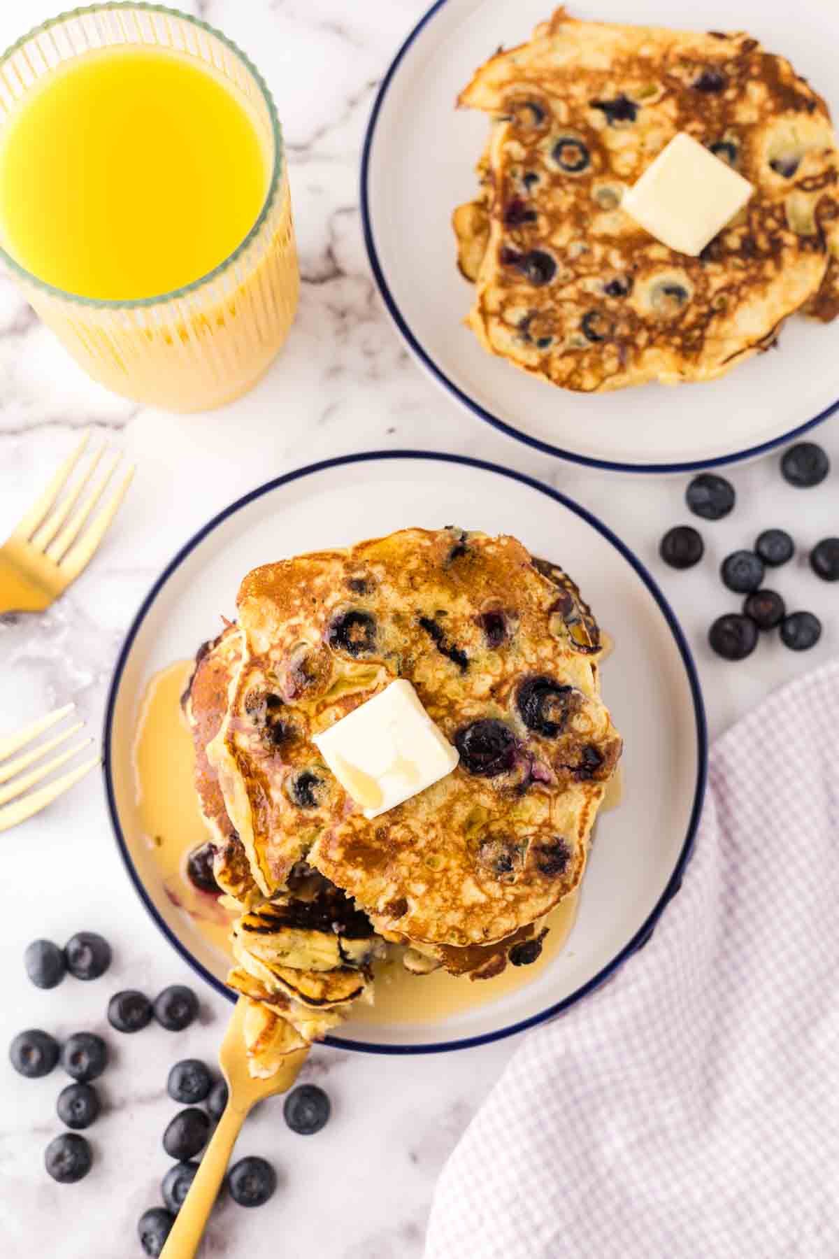 top aesthetic view of fluffy blueberry pancakes with butter and syrup